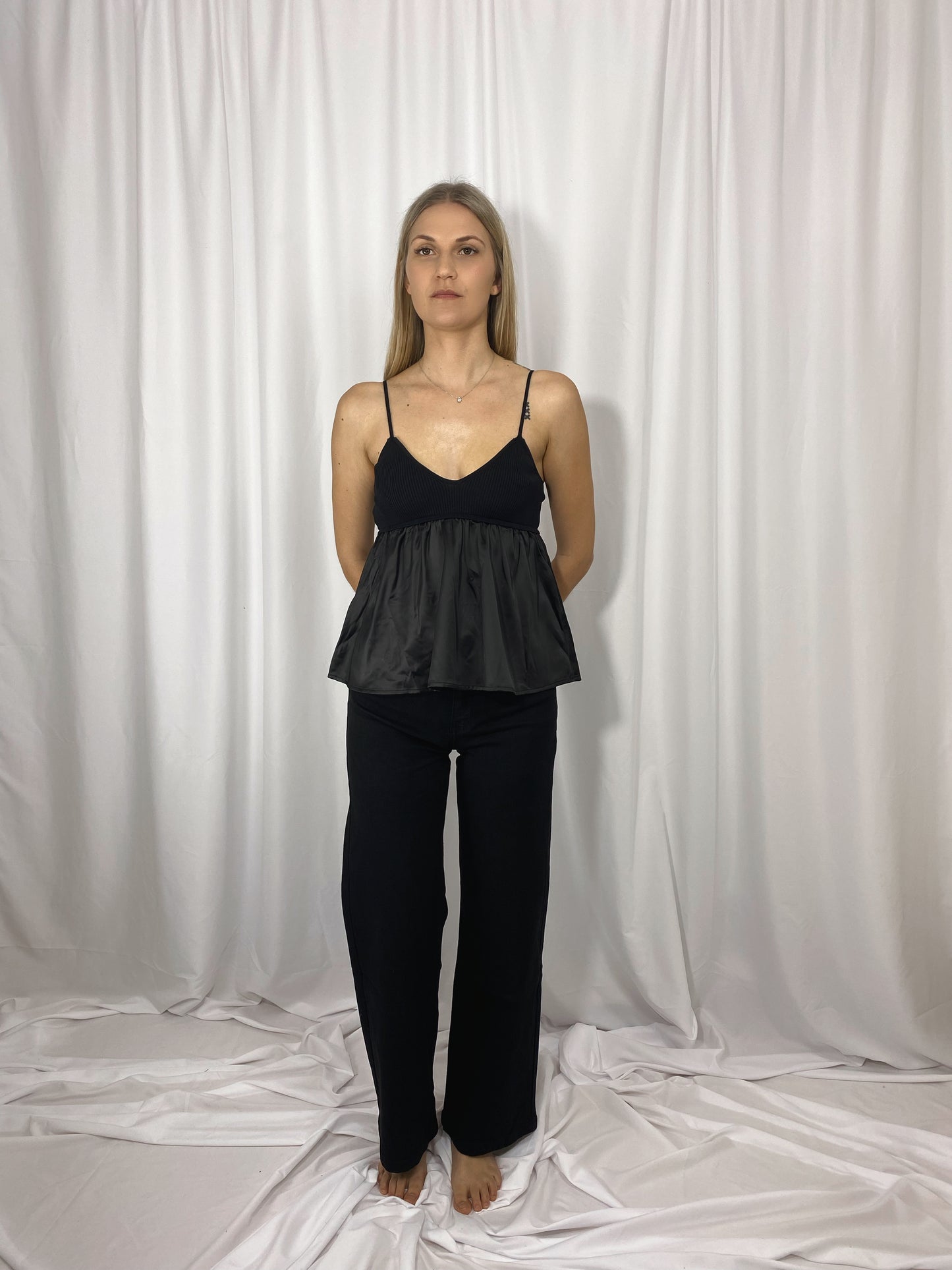 Caraco noir Lola en satin et maille porté avec jean noir
