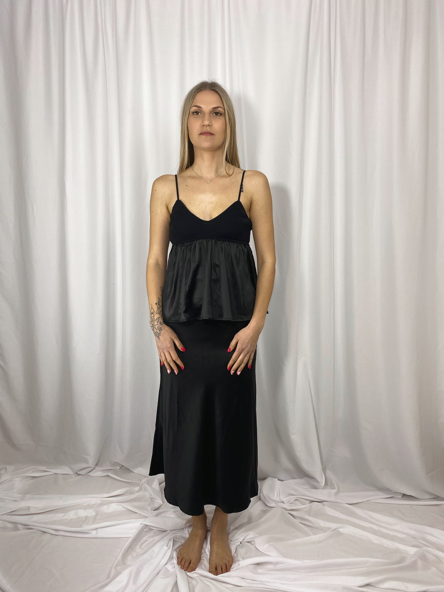 Caraco noir Lola en satin et maille porté avec jupe satinée