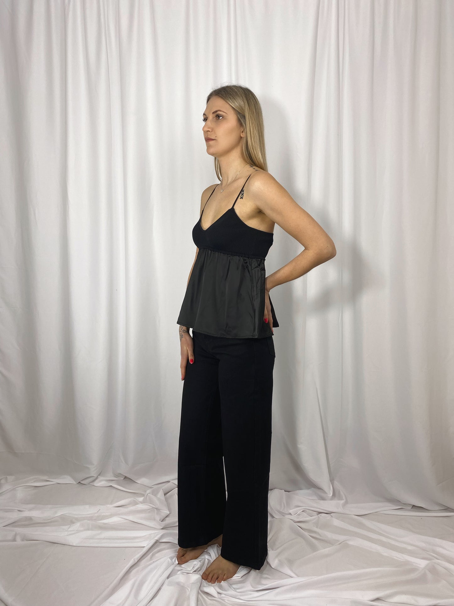 Caraco noir Lola en satin et maille porté avec jean noir