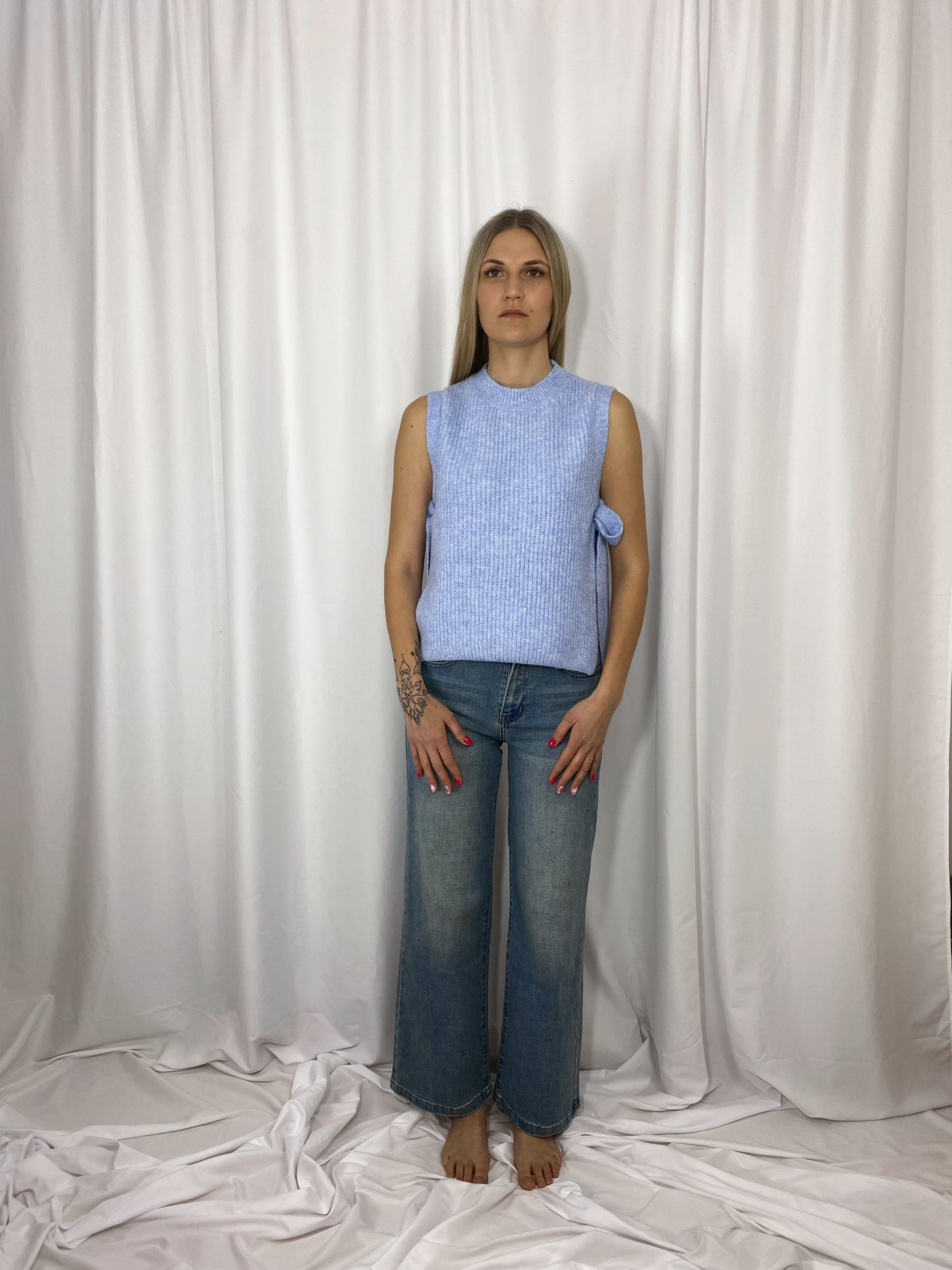 Pull sans manches bleu ciel Alma porté avec jean wide leg

